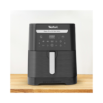 A front view of the Tefal Easy Fry & Grill XXL air fryer with its digital display and control panel, placed on a wooden countertop.